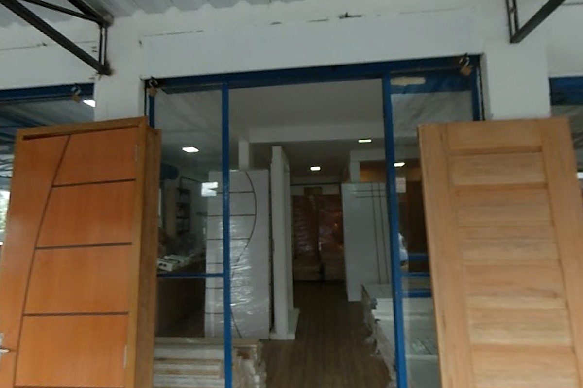 A entrada da loja, com portas de madeira expostas na vitrine
